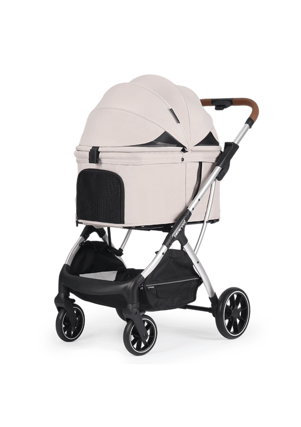 A minimalist beige pet stroller with an enclosed canopy and mesh ventilation panels, supported by a sturdy silver frame and brown leather handle for a refined look.