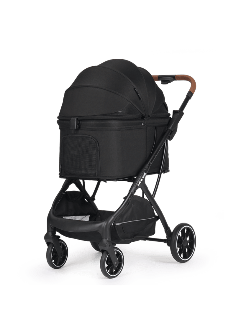 A chic black pet stroller featuring a closed canopy with mesh ventilation, a spacious storage basket underneath, and an elegant brown leather handle.