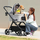 A woman kneeling beside a stroller with her dog sitting comfortably inside. The stroller has a sleek design with a soft, enclosed space for the pet, perfect for outdoor adventures.